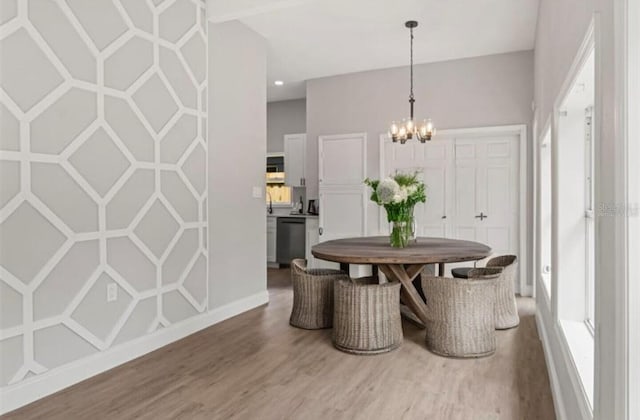 dining area with hardwood / wood-style floors and a notable chandelier