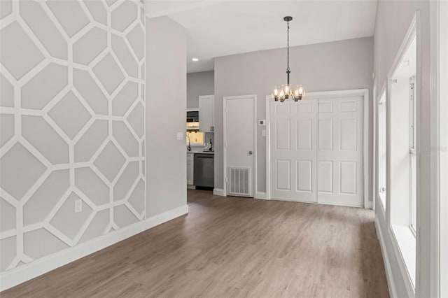 foyer entrance featuring hardwood / wood-style flooring and an inviting chandelier