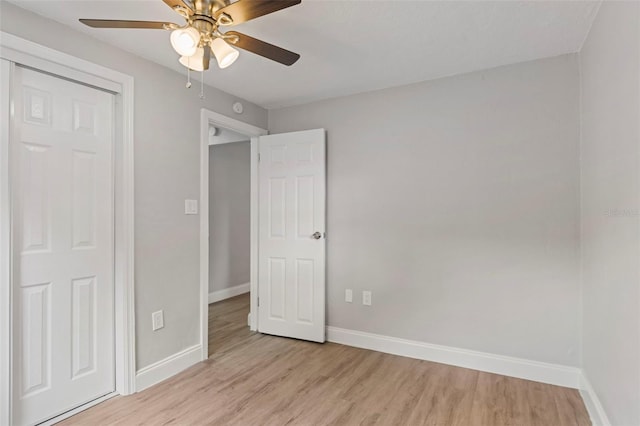 unfurnished bedroom with ceiling fan, light wood-type flooring, and a closet