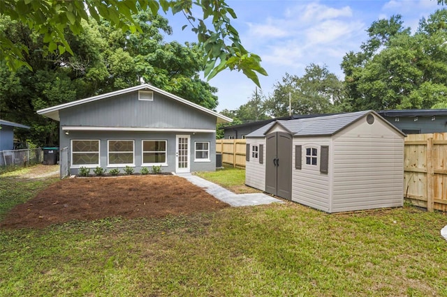 back of property with a shed and a lawn