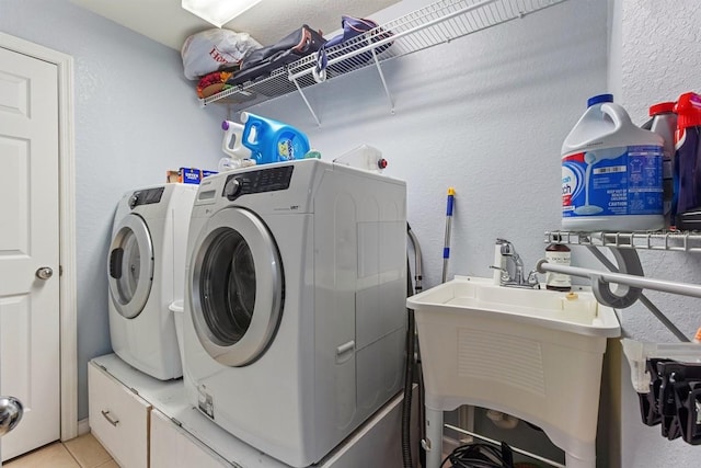 laundry room with separate washer and dryer, light tile patterned floors, and sink