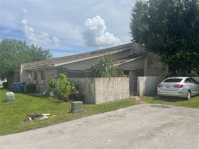 view of side of home with central AC and a yard