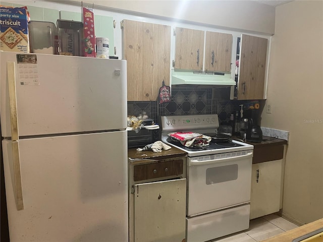 kitchen featuring decorative backsplash, light tile patterned floors, and white appliances