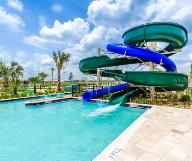 view of swimming pool with a water slide