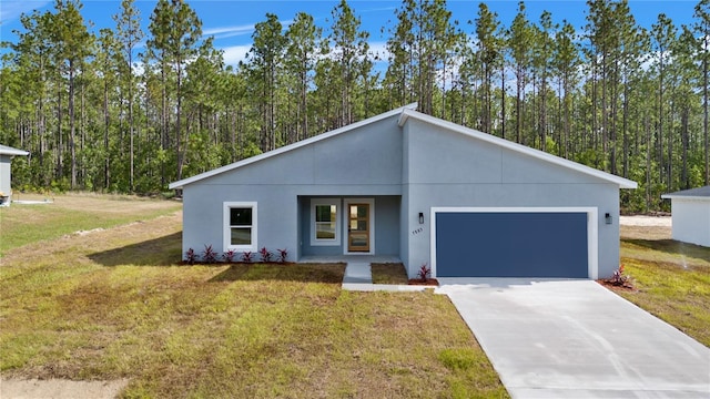 view of front of house with a garage, stucco siding, driveway, and a front lawn