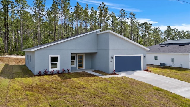 view of front of house with stucco siding, driveway, a front lawn, an attached garage, and central AC unit