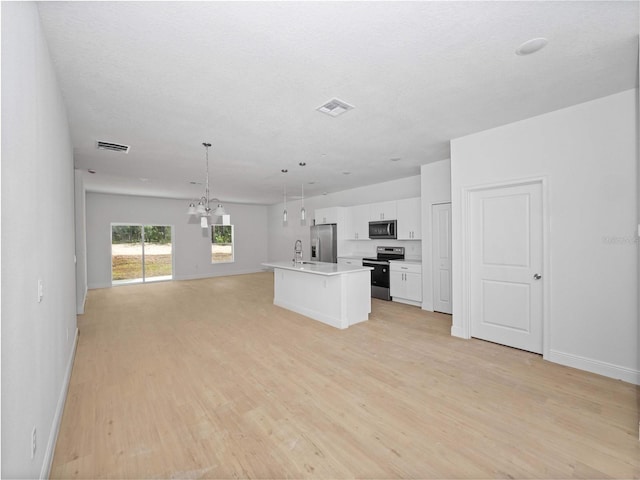 kitchen with visible vents, appliances with stainless steel finishes, open floor plan, and white cabinetry