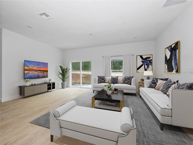 living area featuring wood finished floors, visible vents, and baseboards