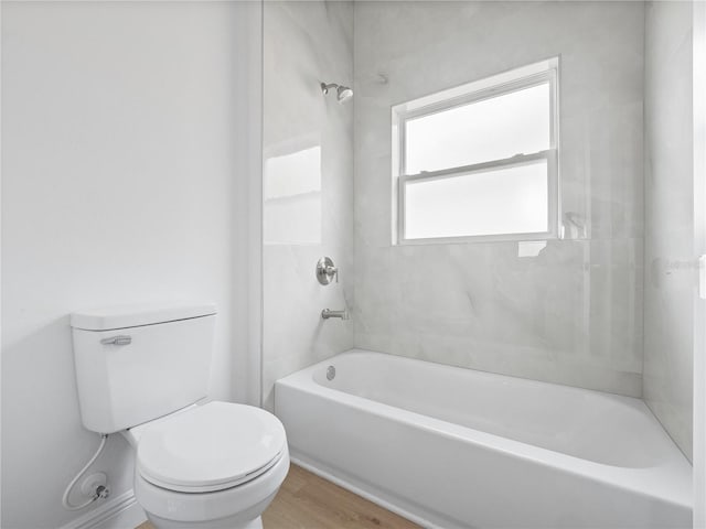 bathroom featuring tiled shower / bath combo, toilet, and hardwood / wood-style flooring