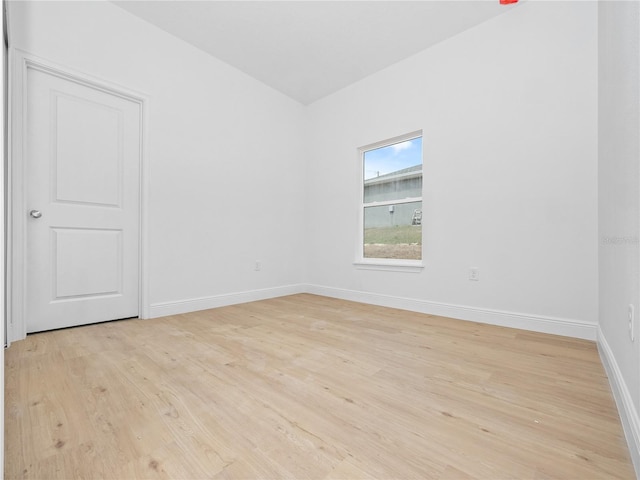 empty room featuring baseboards and light wood finished floors