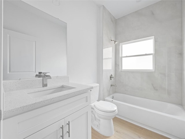 full bathroom with vanity, toilet, tiled shower / bath combo, and hardwood / wood-style flooring