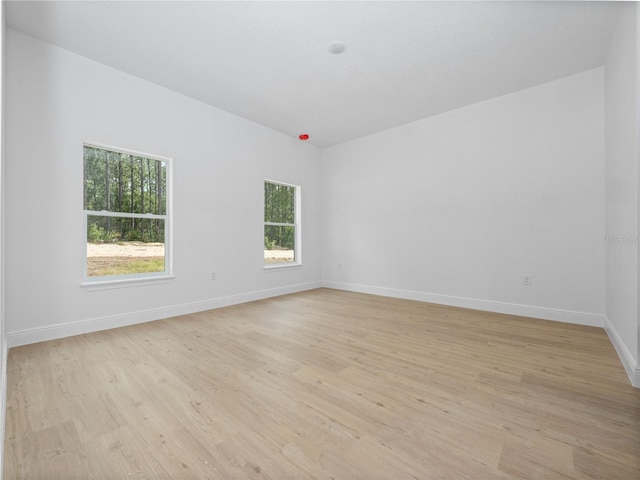 spare room with light wood-style floors and baseboards