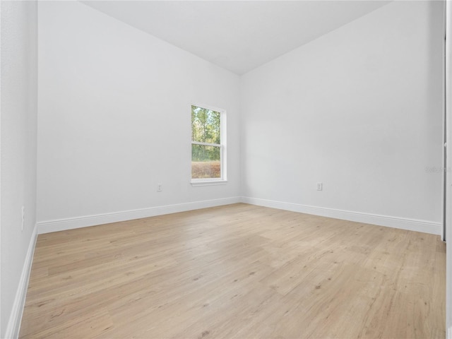 unfurnished room with light wood-type flooring and baseboards