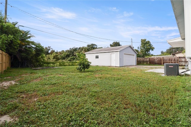 view of yard with a garage, cooling unit, and an outdoor structure