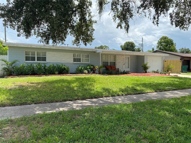 ranch-style house featuring a garage and a front lawn