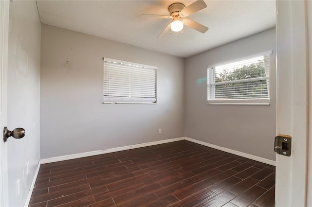 empty room with ceiling fan and dark wood-type flooring