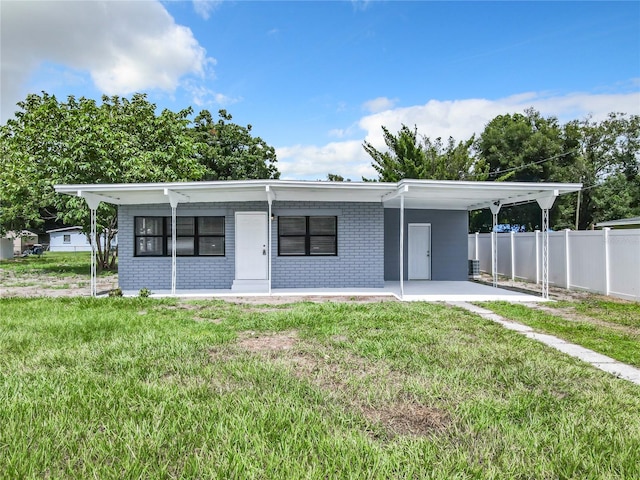 view of front facade featuring a front yard and a carport