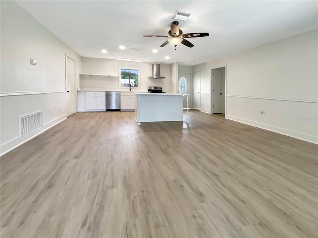 kitchen with visible vents, wall chimney exhaust hood, stainless steel appliances, and white cabinets