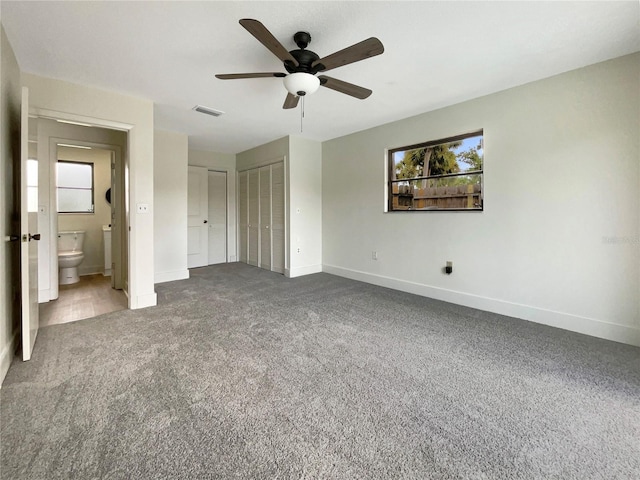 unfurnished bedroom with baseboards, visible vents, carpet floors, and connected bathroom