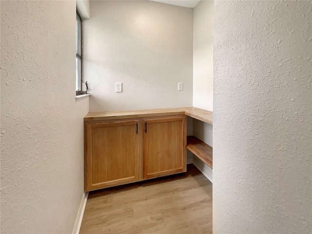 interior space with light wood-style flooring and a textured wall