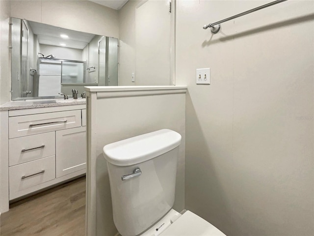 bathroom featuring vanity, toilet, and wood finished floors