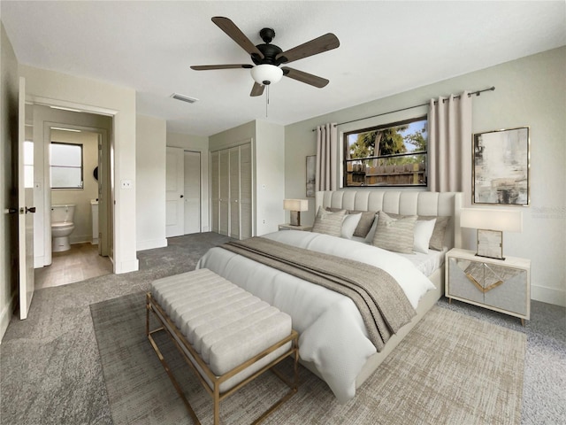 carpeted bedroom featuring visible vents, ensuite bath, baseboards, and a ceiling fan