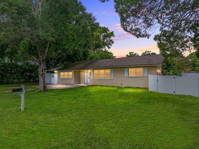 ranch-style home featuring a gate, a front yard, and fence