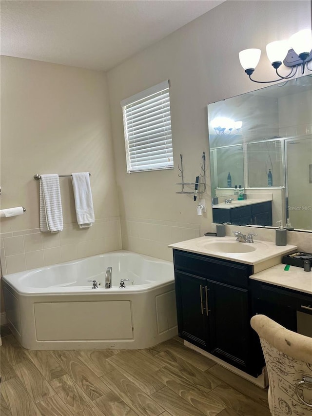 bathroom with hardwood / wood-style flooring, shower with separate bathtub, and vanity