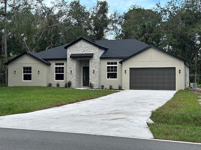 view of front facade with a garage, central AC unit, and a front yard