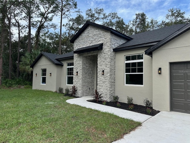 view of front of home with a front yard and a garage