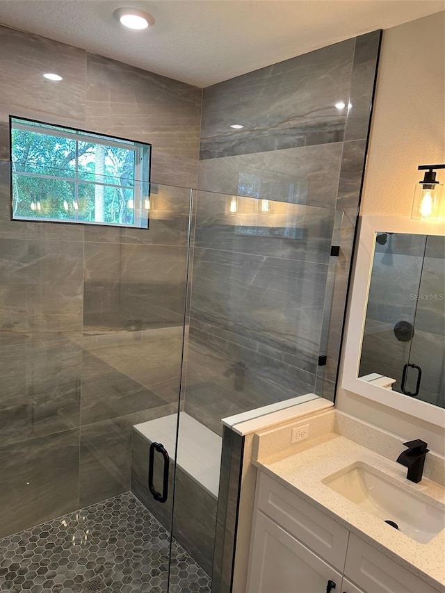 bathroom featuring walk in shower and vanity