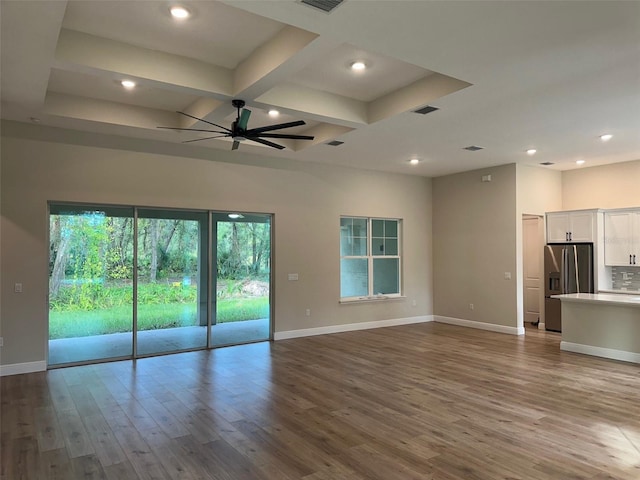 unfurnished living room with beamed ceiling, light hardwood / wood-style floors, ceiling fan, and coffered ceiling