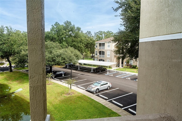 view of parking with a lawn and a carport