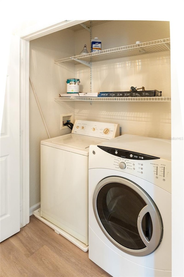 washroom with light wood-type flooring and washer and dryer