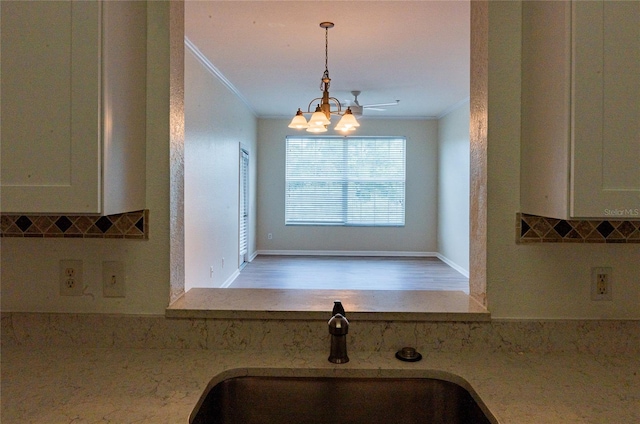 interior space featuring ornamental molding, an inviting chandelier, decorative light fixtures, and sink