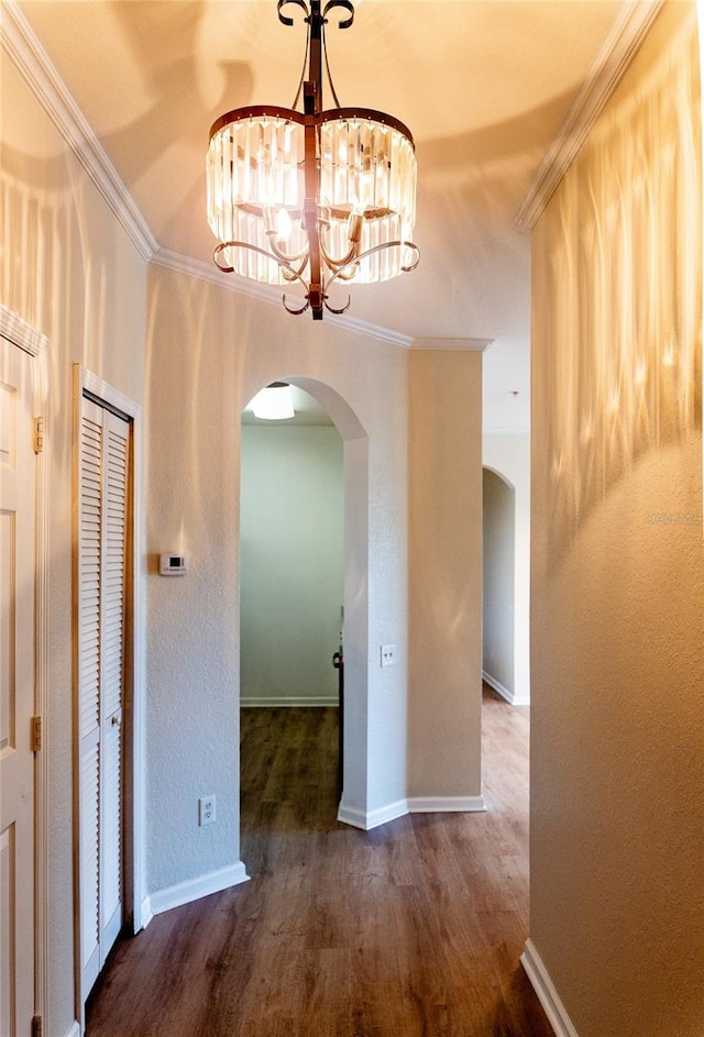 interior space with crown molding, a notable chandelier, and wood-type flooring