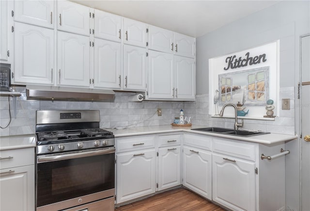 kitchen with gas stove, light hardwood / wood-style floors, tasteful backsplash, sink, and white cabinets