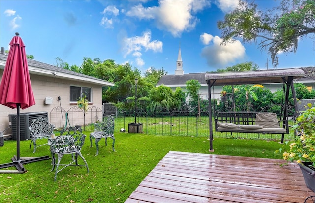 wooden terrace with central air condition unit and a yard