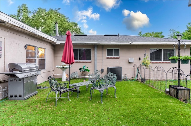 back of property featuring central AC and a lawn