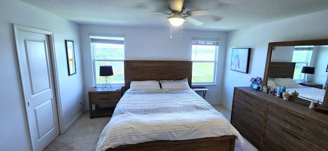 carpeted bedroom with a textured ceiling and ceiling fan