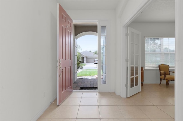 entrance foyer with light tile patterned floors and a healthy amount of sunlight