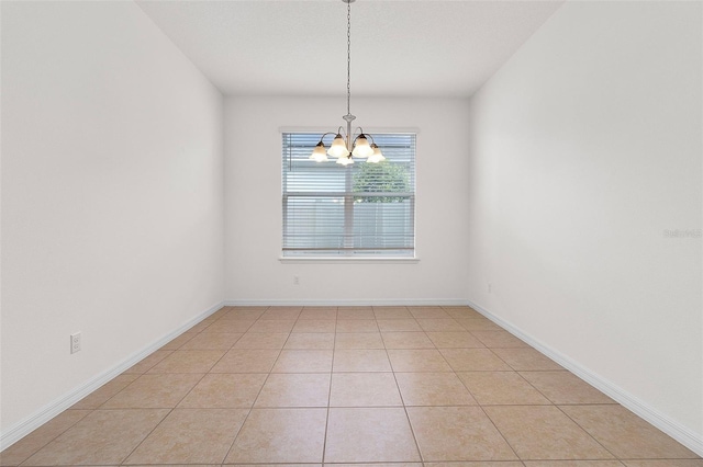 spare room featuring a chandelier and light tile patterned floors