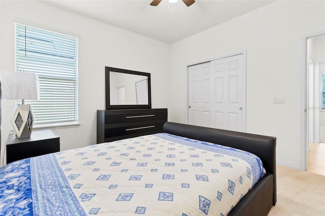 carpeted bedroom with ceiling fan and a closet