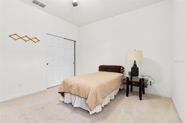 carpeted bedroom with ceiling fan and a closet