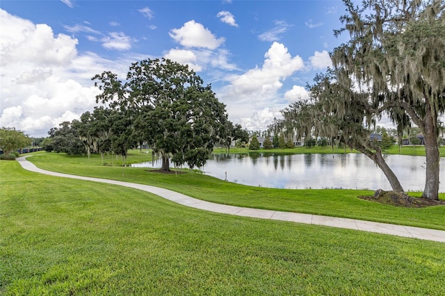 view of property's community with a lawn and a water view