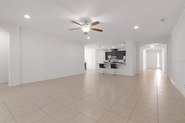 unfurnished living room featuring light tile patterned floors and ceiling fan