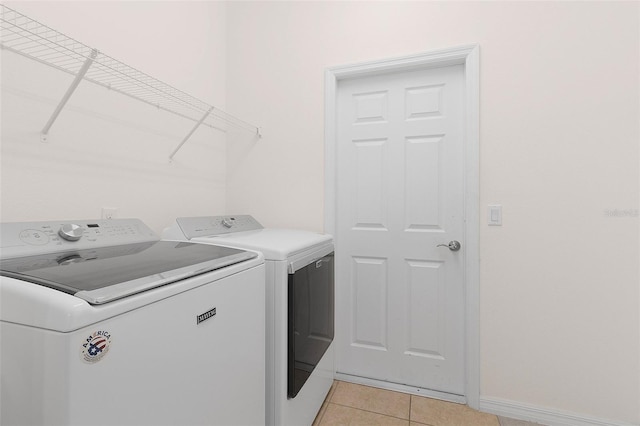 clothes washing area featuring light tile patterned flooring and independent washer and dryer