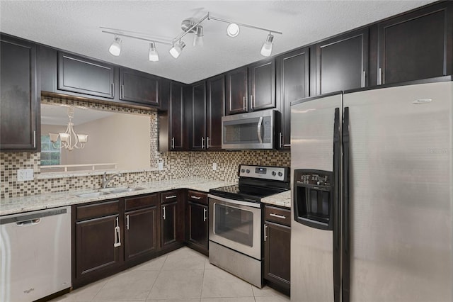 kitchen featuring appliances with stainless steel finishes, dark brown cabinets, a chandelier, and sink