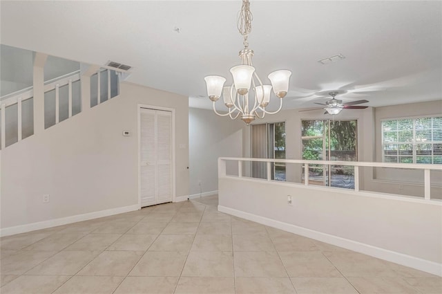 spare room featuring light tile patterned floors and ceiling fan with notable chandelier