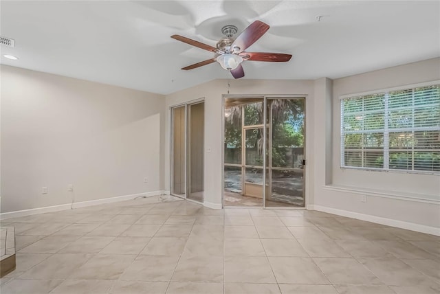 tiled spare room featuring ceiling fan